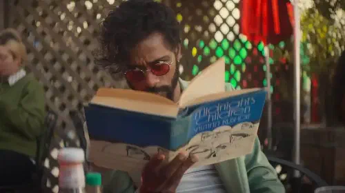 assets/lakeith-stanfield-looking-up-from-holding-his-book-intrigued-in-i-love-boosters.jpeg