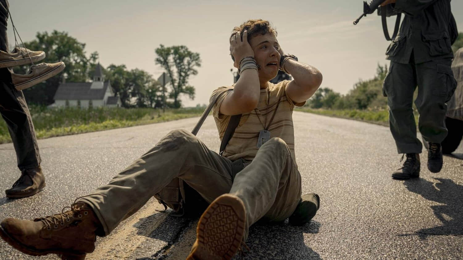 a-young-man-in-panic-sitting-in-the-middle-of-the-road-in-the-long-walk.jpeg