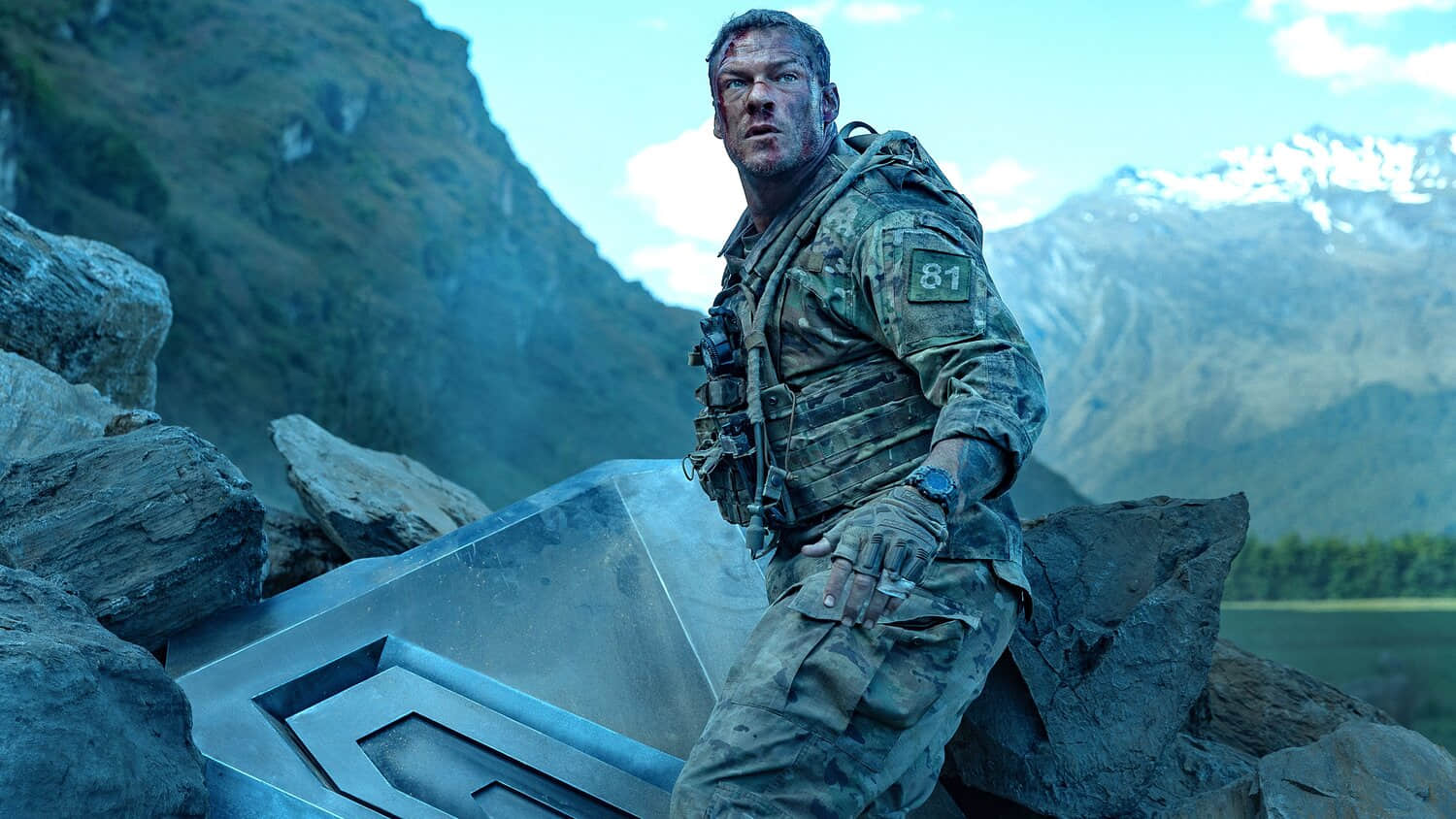 alan-ritchson-s-81-standing-next-to-part-of-the-destroyed-machine-and-looking-beat-up-in-war-machine.jpeg