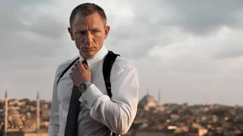 assets/daniel-craig-in-skyfall-holding-his-tie-with-a-city-in-the-back-ground.jpeg