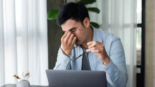 assets/Man-pinching-tired-eyes-with-glasses-off-while-working-at-laptop-on-desk-2.jpeg