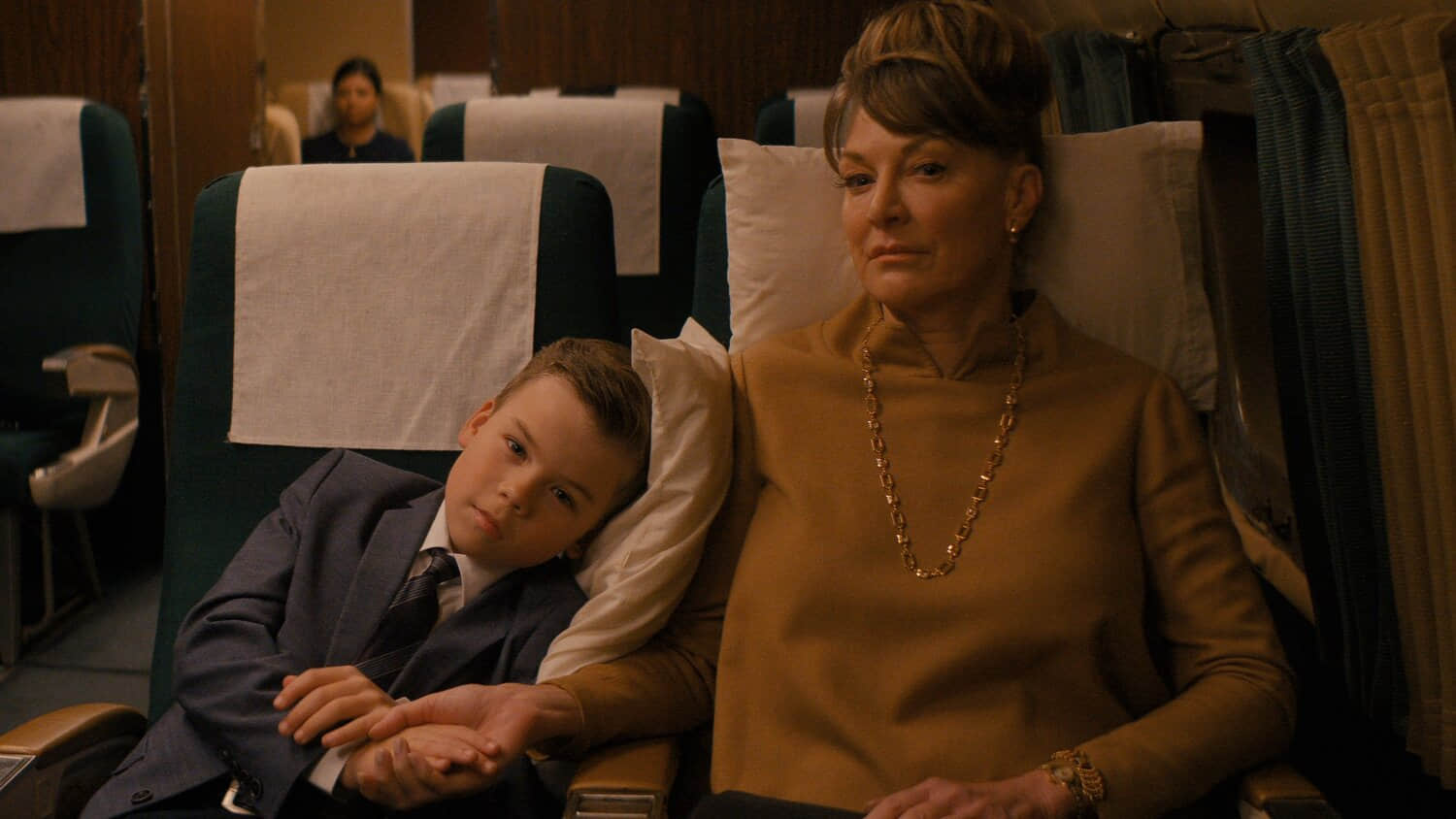 jeff-leaning-on-his-mother-while-seated-in-the-plane-in-propeller-one-way-night-coach.jpeg