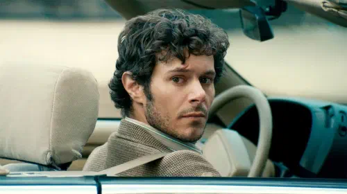 assets/adam-brody-as-abe-gazing-at-someone-from-the-front-seat-of-his-car-in-the-kid-detective.jpeg