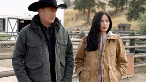 assets/kelsey-asbille-and-kevin-costner-standing-together-in-yellowstone.jpeg