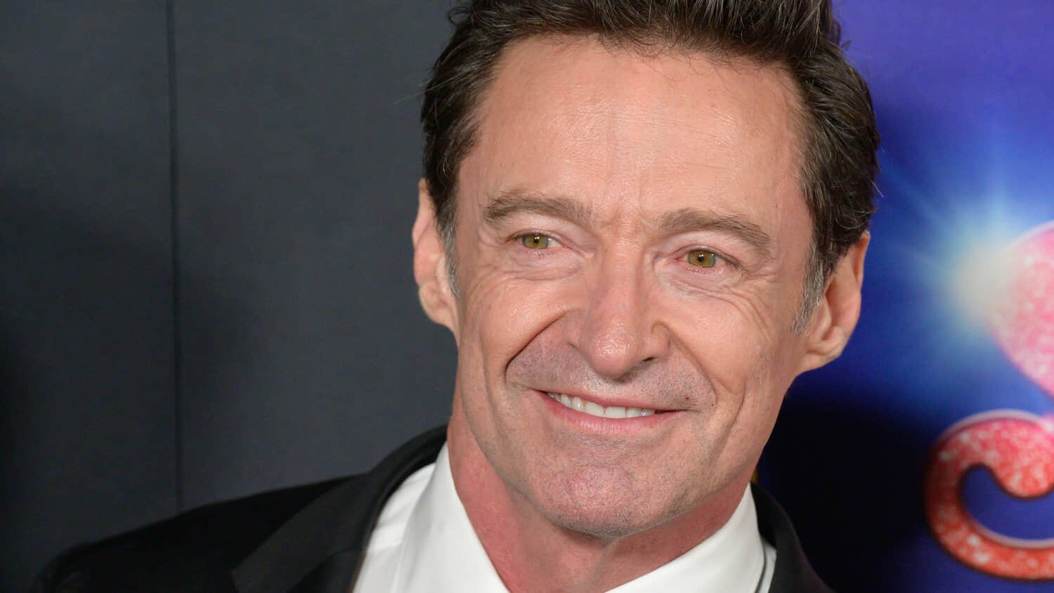 hugh-jackman-smiling-for-a-photo-on-the-song-sung-blue-red-carpet.jpeg
