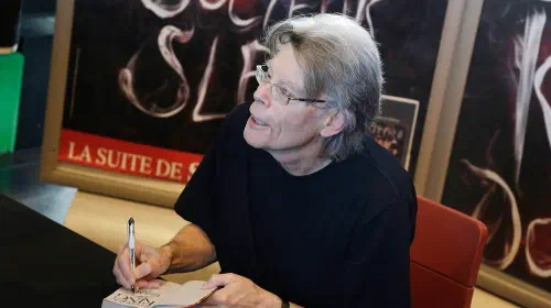 assets/stephen-king-signing-a-book.jpeg