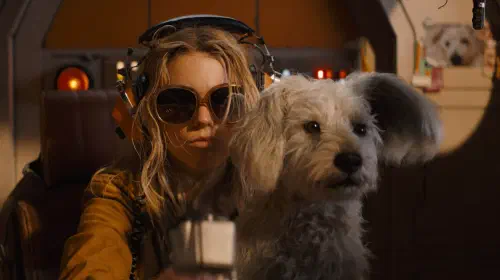 assets/kara-wearing-sunglasses-while-krypto-sits-on-her-lap-in-supergirl.jpeg