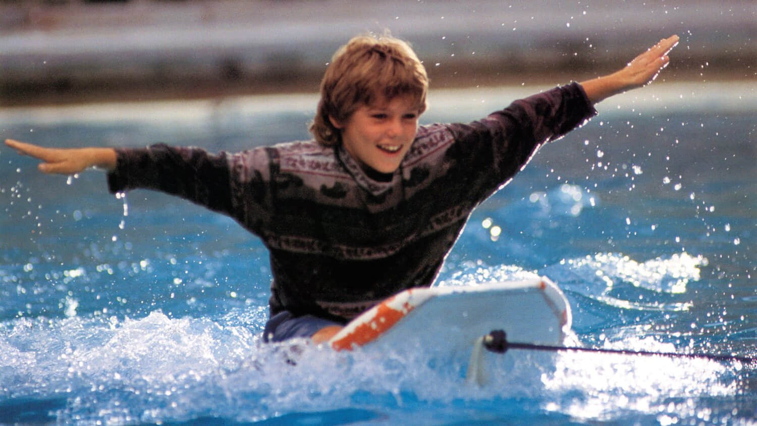 jesse-with-his-arms-spread-on-a-boogey-board-in-free-willy.jpeg