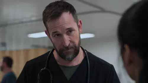 assets/noah-wyle-as-robby-with-his-head-tilted-in-the-pitt-season-2-episode-15.jpeg