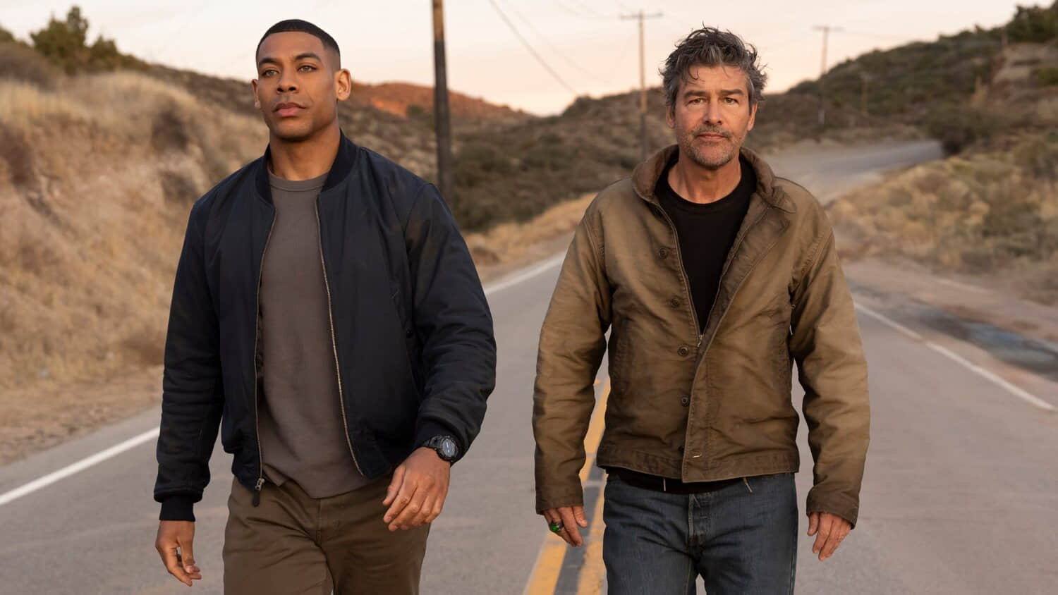 aaron-pierre-and-kyle-chandler-walking-down-a-road-in-lanterns.jpeg