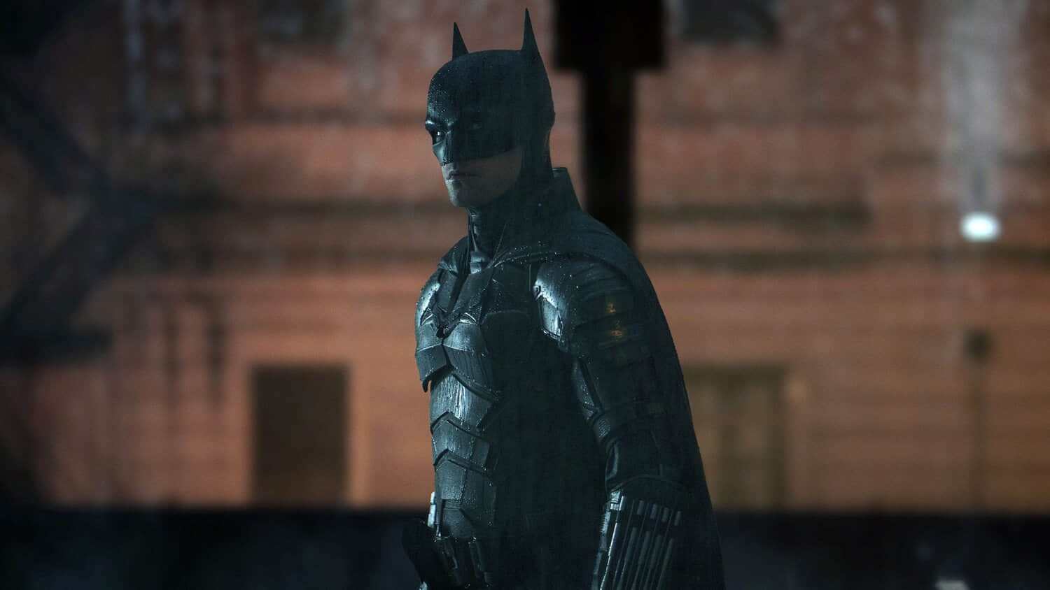 robert-pattinson-as-batman-standing-in-front-of-a-building-in-the-batman.jpeg