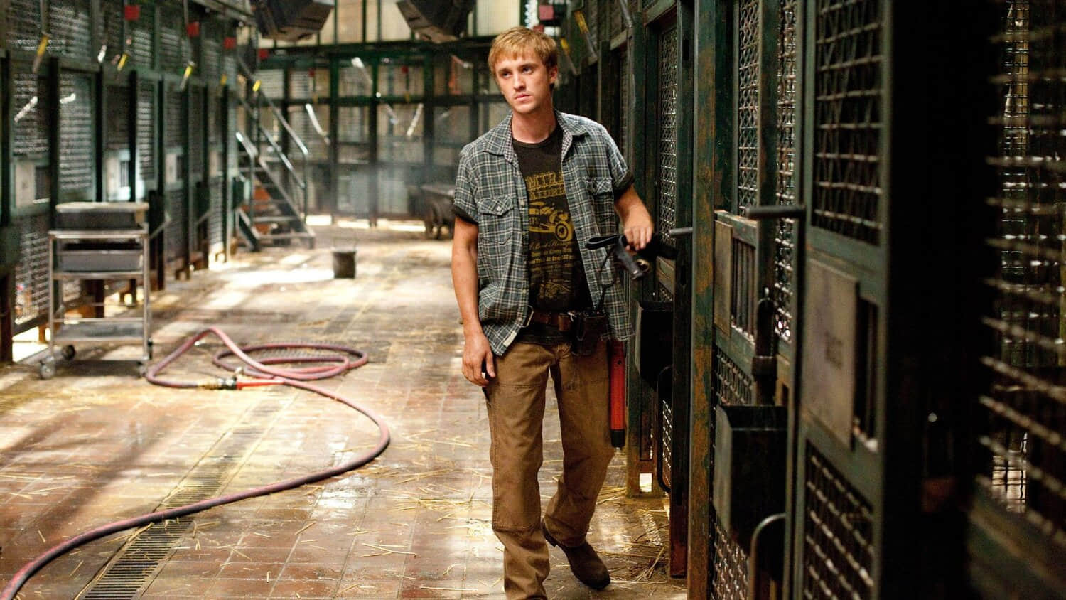 tom-felton-walks-by-cages-in-rise-of-the-planet-of-the-apes.jpeg