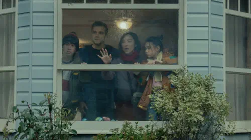 assets/the-trapped-delgados-huddled-around-their-window-in-the-last-house.jpeg