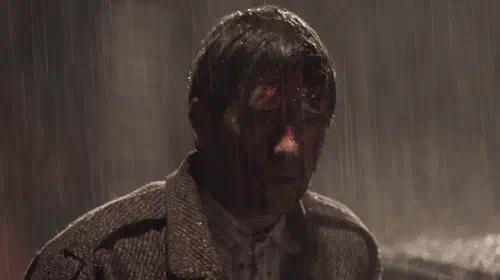 assets/a-man-stands-in-the-rain-in-dark-2017.jpeg