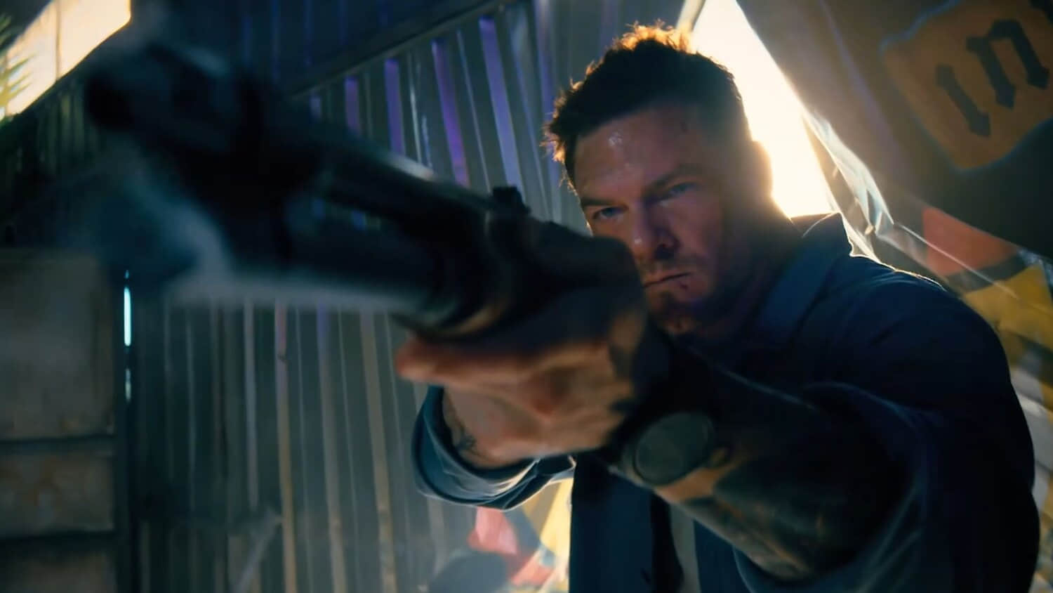 alan-ritchson-s-hank-aiming-a-shotgun-toward-the-camera-in-runner.jpeg