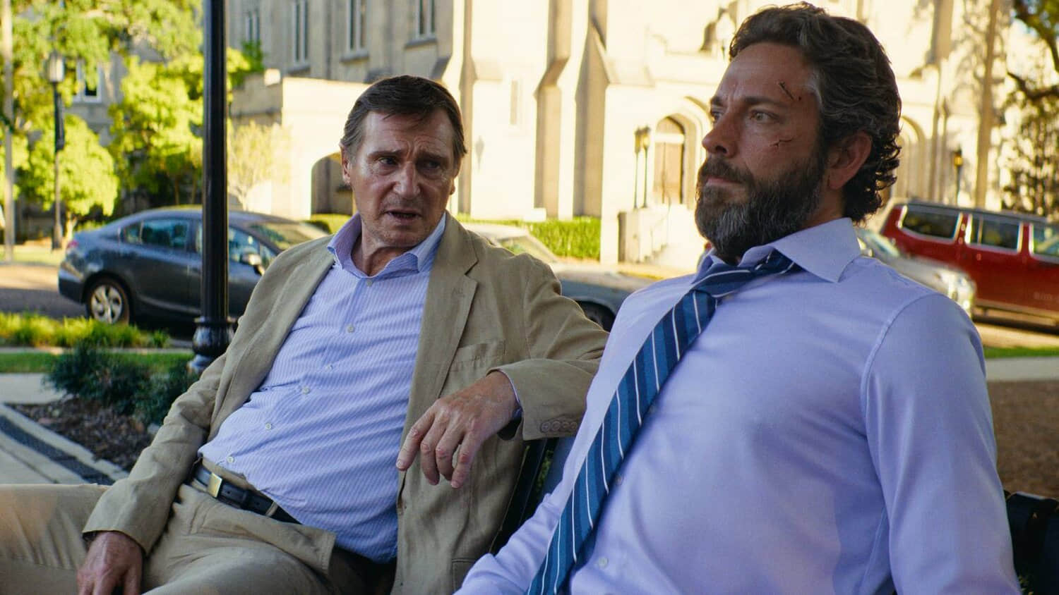 liam-neeson-and-zachary-levi-talking-on-a-park-bench-in-the-fix.jpeg