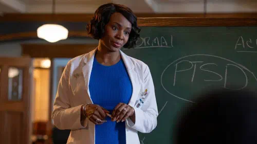 assets/tamberla-perry-standing-in-front-of-a-chalkboard-in-brilliant-minds.jpeg