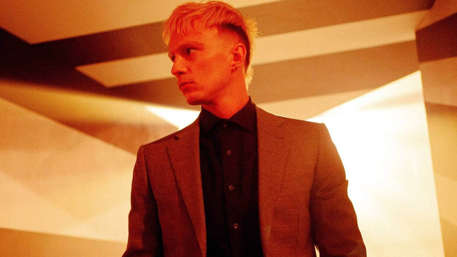 drew-starkey-looking-to-his-right-in-a-warmly-lit-room-in-onslaught.jpeg