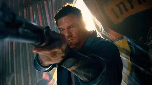 assets/alan-ritchson-holding-shotgun-in-runner.jpeg