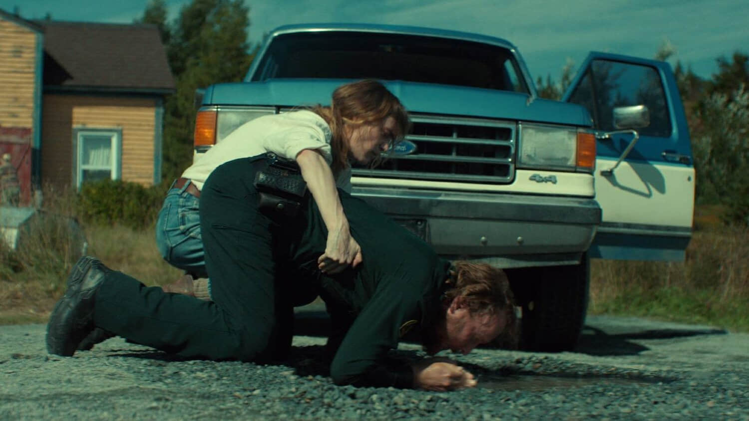 a-man-kneeling-and-a-woman-holding-him-in-front-of-a-blue-car-in-below.jpeg